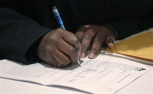 FILE - In this April 22, 2015, file photo, a job seeker fills out an application during a National Career Fairs job fair in Chicago. The Labor Department said Thursday, Jan. 14, 2016, applications for jobless aid rose 4,000 to a seasonally adjusted 284,000. (AP Photo/M. Spencer Green, File)