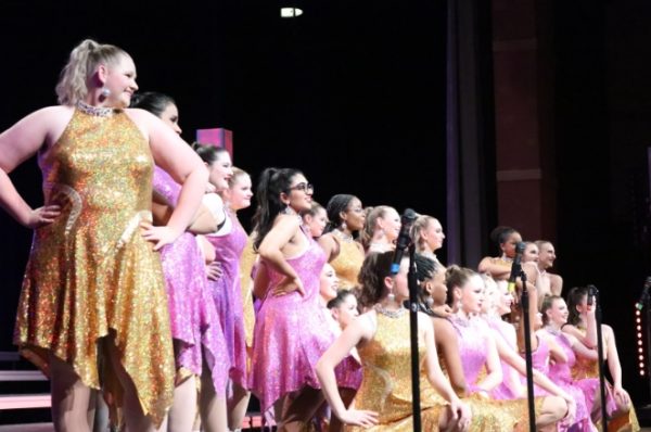 The She-notes perform “I Will Survive” by Gloria Gaynor. Dressed brightly in pink and gold, the girls receive applause from the crowd. 