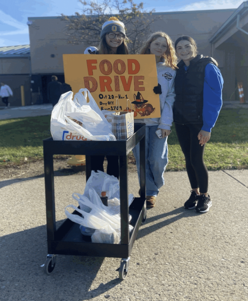 Service club members collect cans for the food drive. 