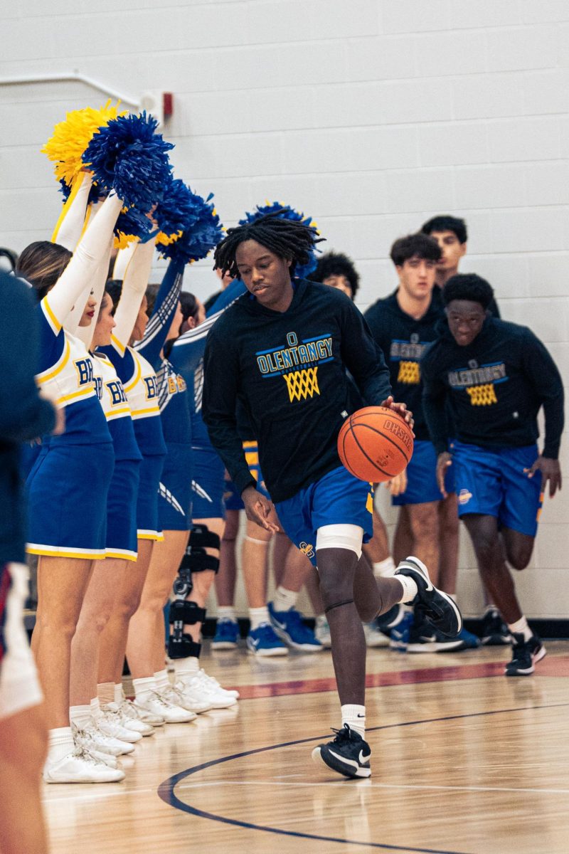 Senior captain, Quentin Page walks out ready to play. The team is hyped up by the cheer team and student section. 