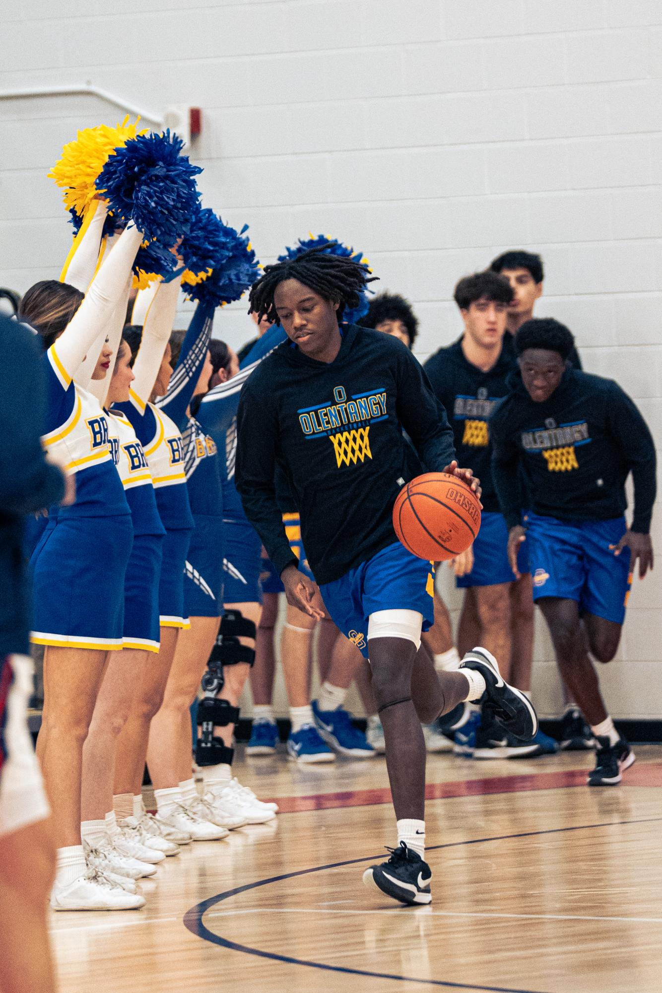 Senior captain, Quentin Page walks out ready to play. The team is hyped up by the cheer team and student section. 
